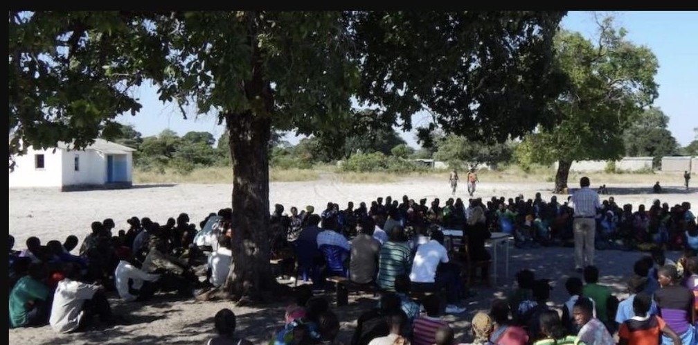 ACE D&H facilitating a community consultation under a tree, with residents gathered to take part in the discussion.